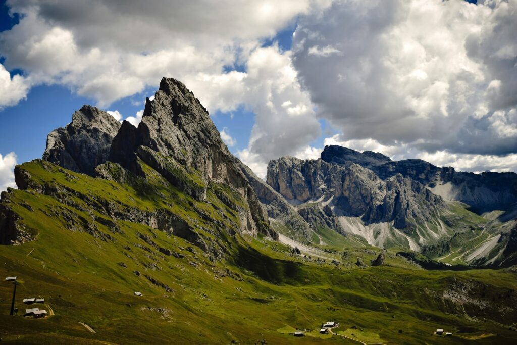 A distant collection of cabins in the shadow of a large mountain