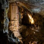 People walk along a footbridge inside a cave