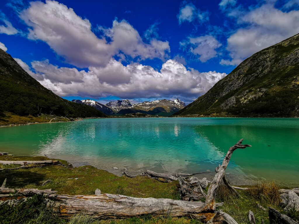 Patagonian landscape shot showcasing mountains, azure lake, and dramatic clouds